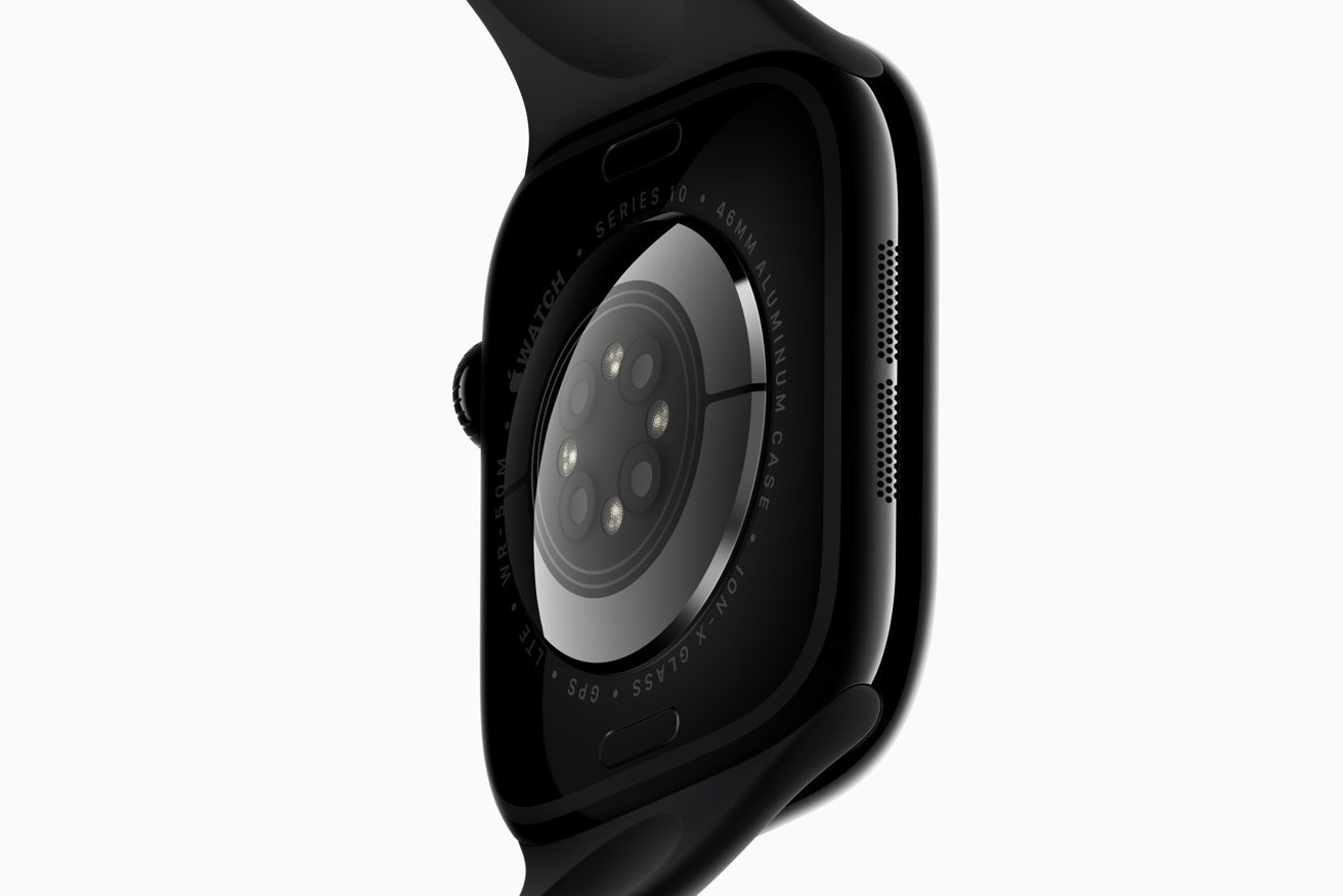Close-up of the back of a black smartwatch with multiple sensors and a green wristband.