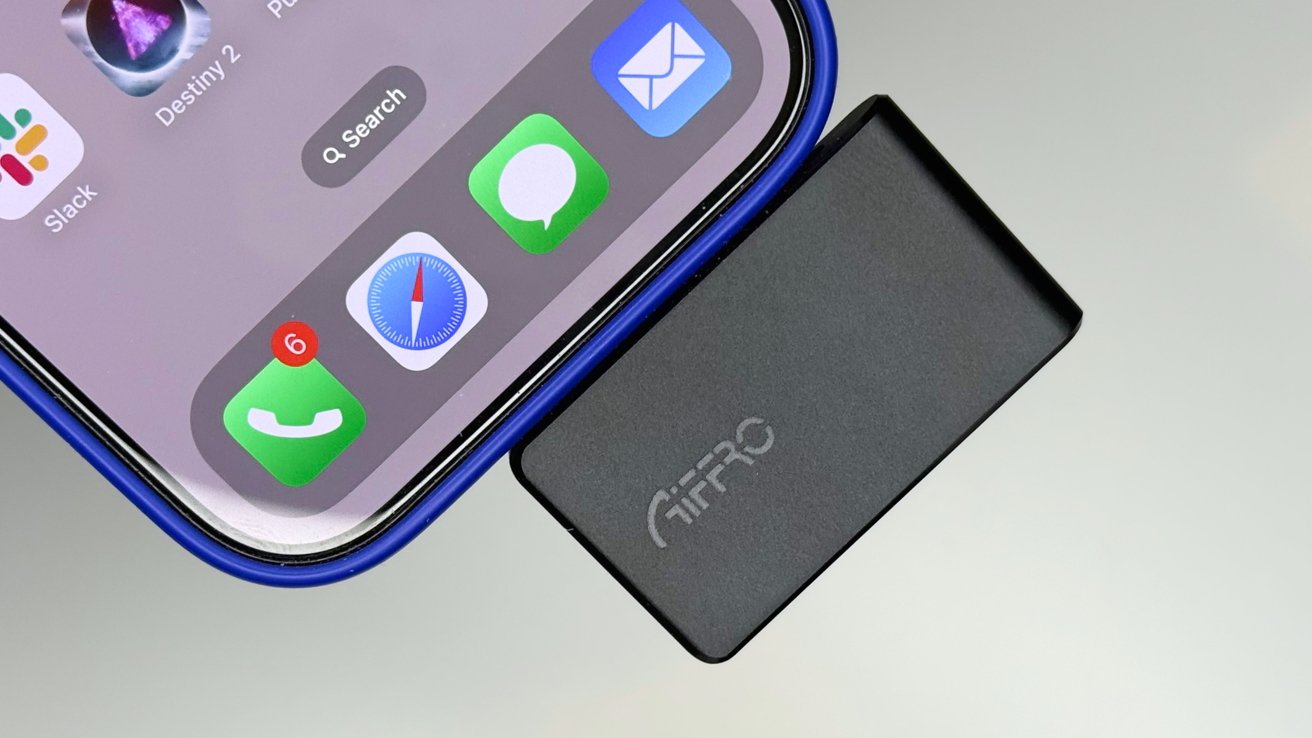 Close-up of a smartphone screen with app icons, including Slack, messages, and phone, next to a small black rectangular device labeled 'Aifro.'